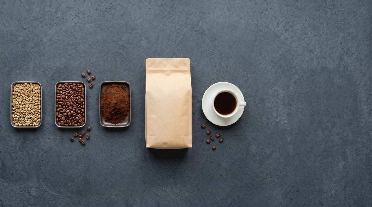 Green, roasted and ground coffee, a kraft bag and a served cup, lined up on dark stone