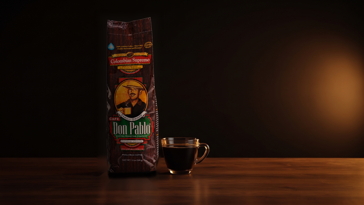 A bag of Don Pablo Colombian Supremo next to a glass cup of black coffee